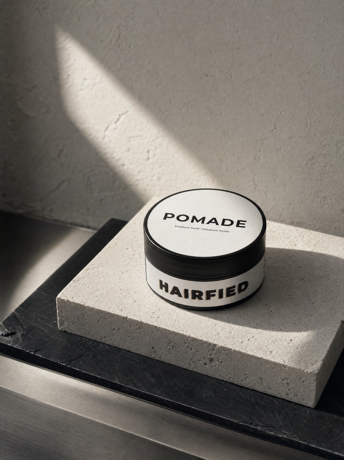 Hairfied Pomade on a travertine block in raking sunlight